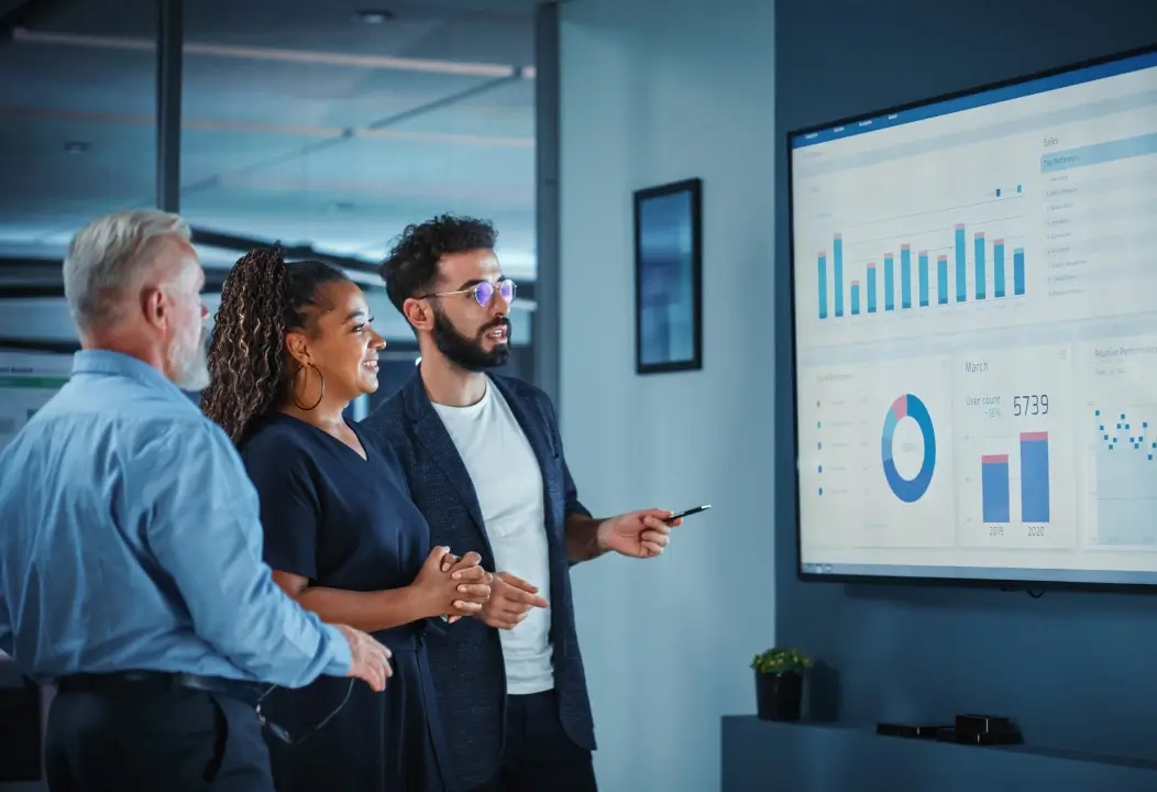 A man in a suit stands before a large screen displaying "qa consulting and audit"
